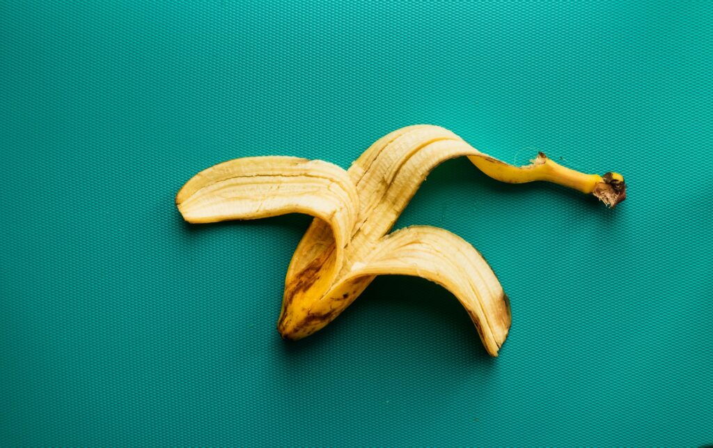 A discarded banana peel on a teal background, the edible part most people skip when eating banana peels isn't the norm