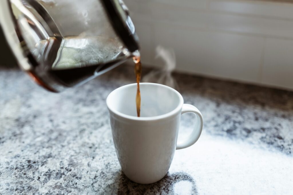 a person pours black coffee, which is one of many healthy drinks besides water
