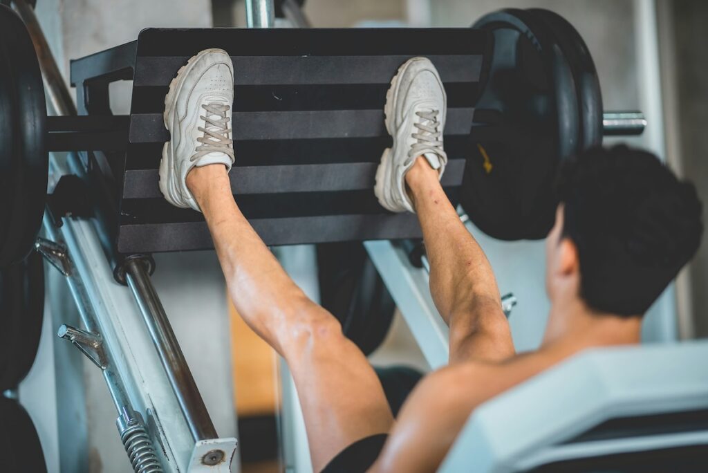 a man uses proper foot placement to target glutes on leg press