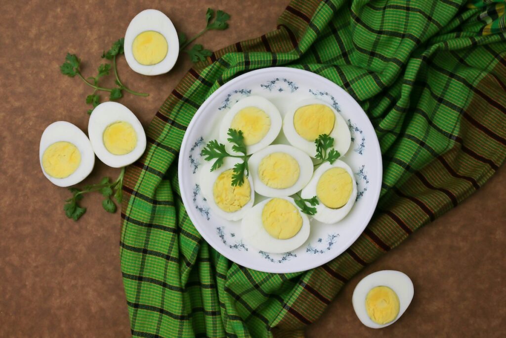 Halved hard-boiled eggs on a white plate garnished with parsley, an easy-to-digest way to enjoy eggs when considering whether eggs are good for gut health