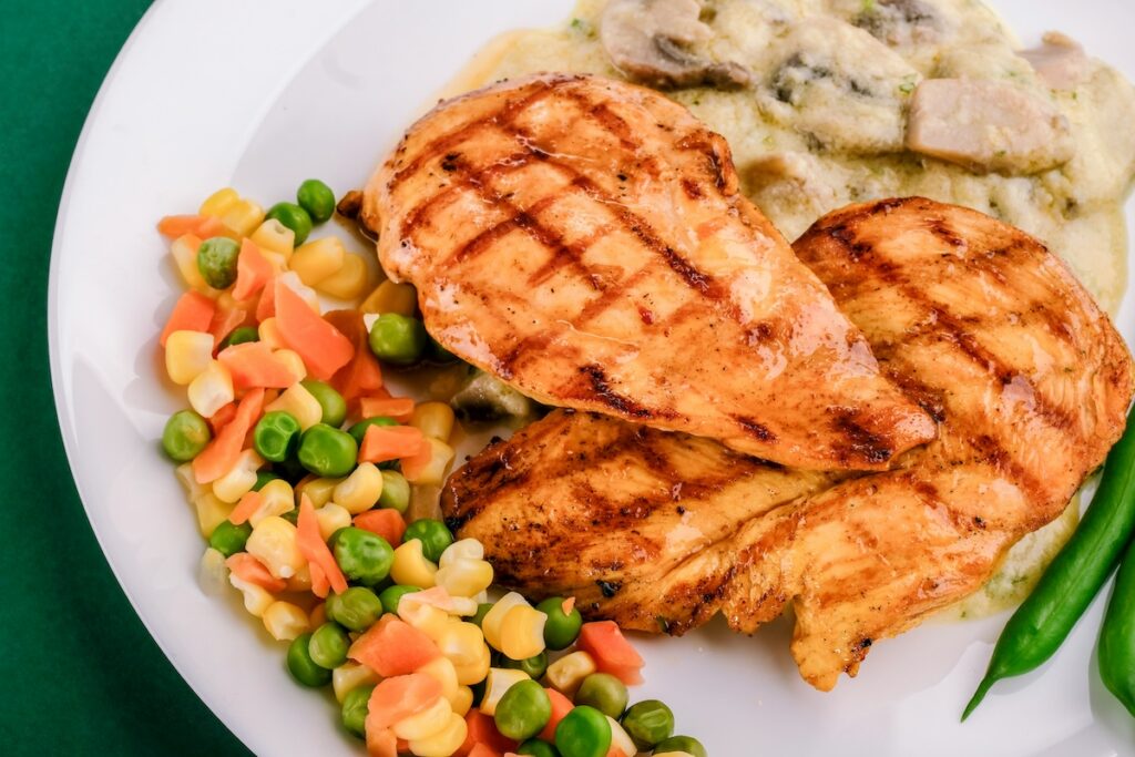 Grilled chicken breast with vegetables, a high-protein meal that supports how long does it take to grow glutes through proper nutrition