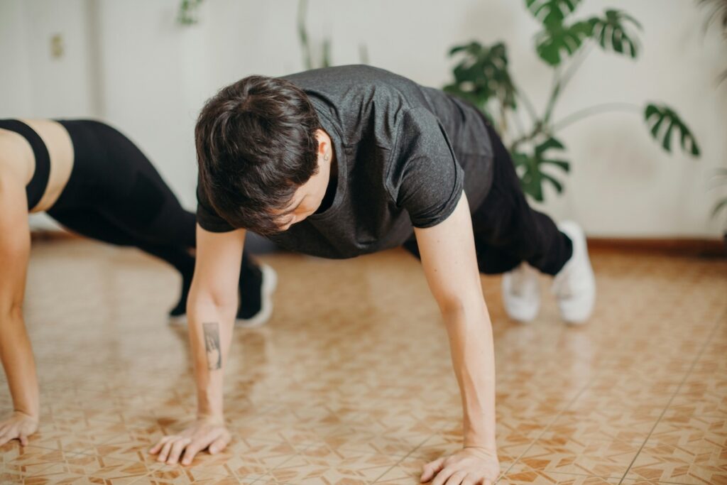people doing push-ups by age fitness test together indoors on tiled floor