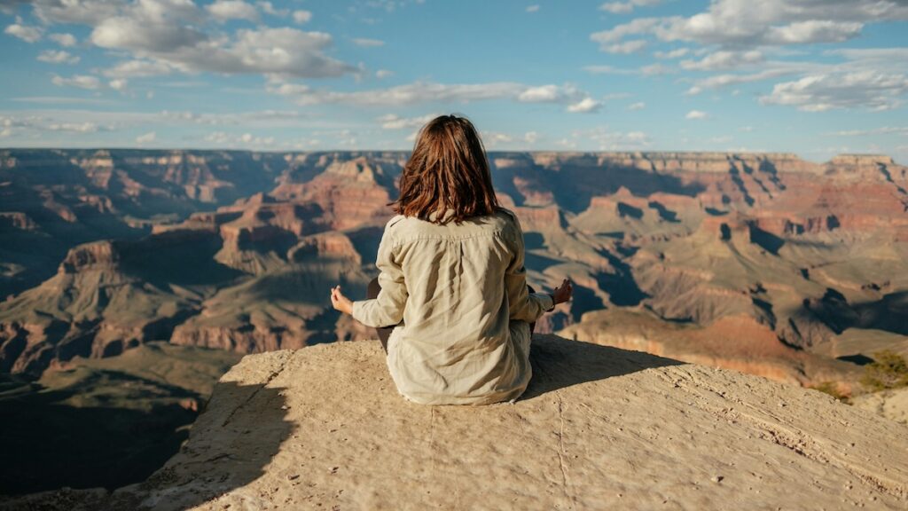 a woman meditates to help reduce stress, and therefore, reduce cortisol belly
