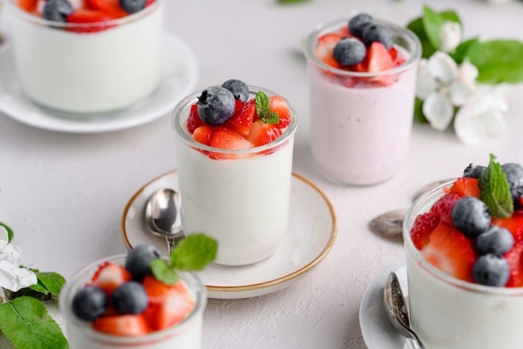 Low-calorie fruits like strawberries and blueberries paired with Greek yogurt in glass jars