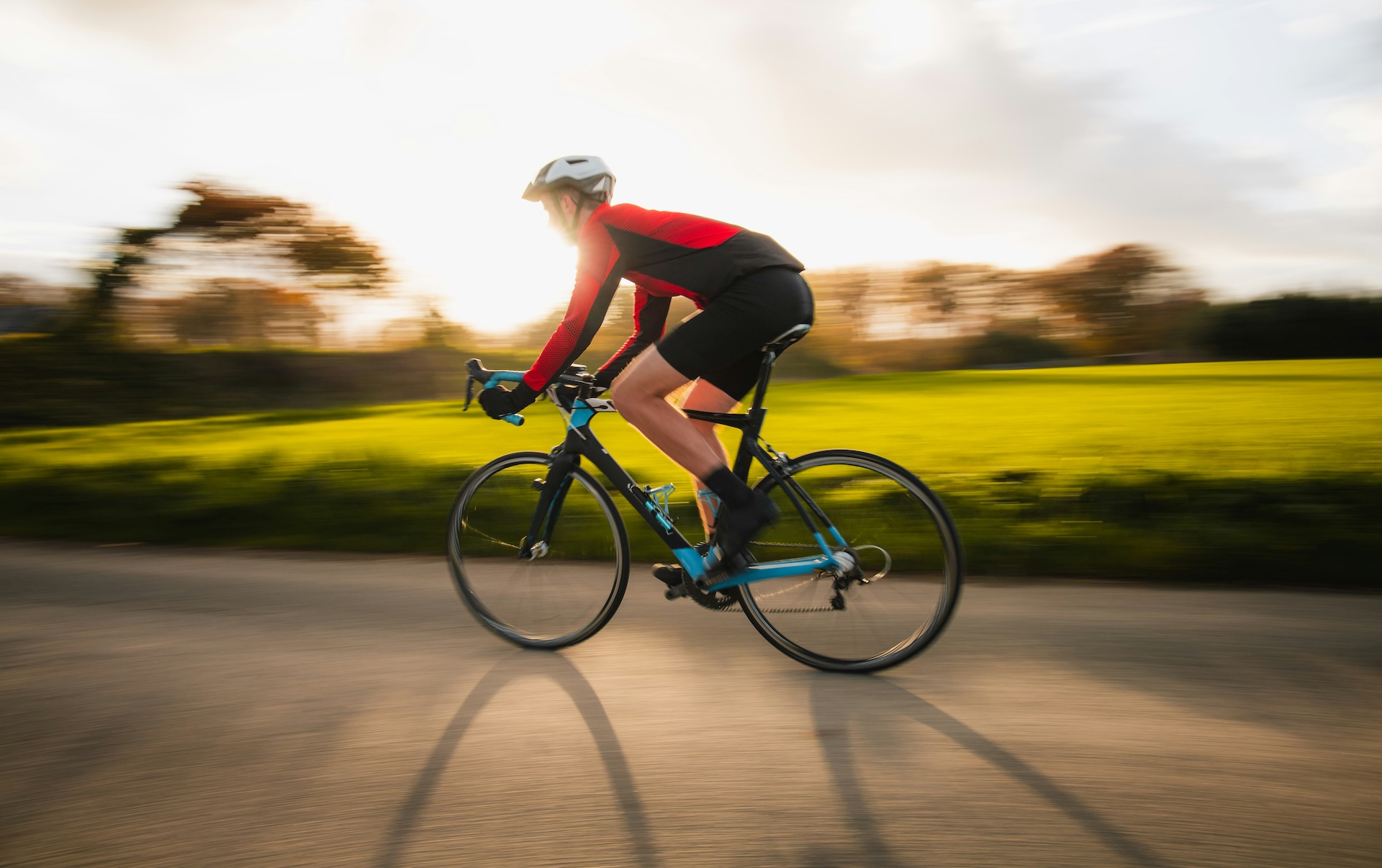 Cyclist on a road bike at sunset, illustrating the cycling and memory benefits highlighted in new brain research.