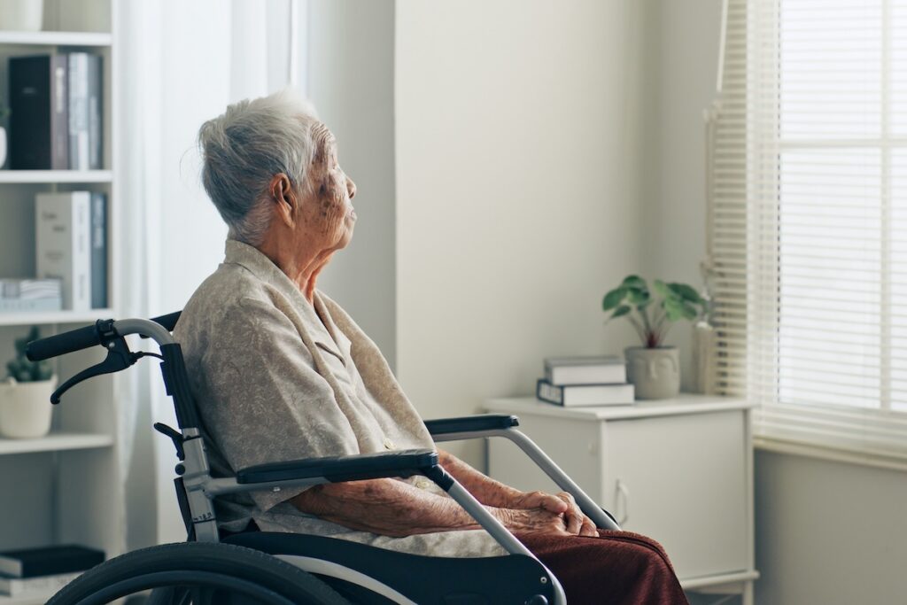 Elderly woman in a wheelchair, reflecting the link between optimism and health as we age