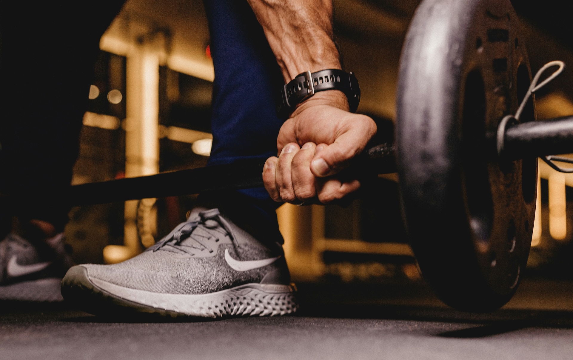 Close-up of hand gripping a barbell during deadlift to build grip strength