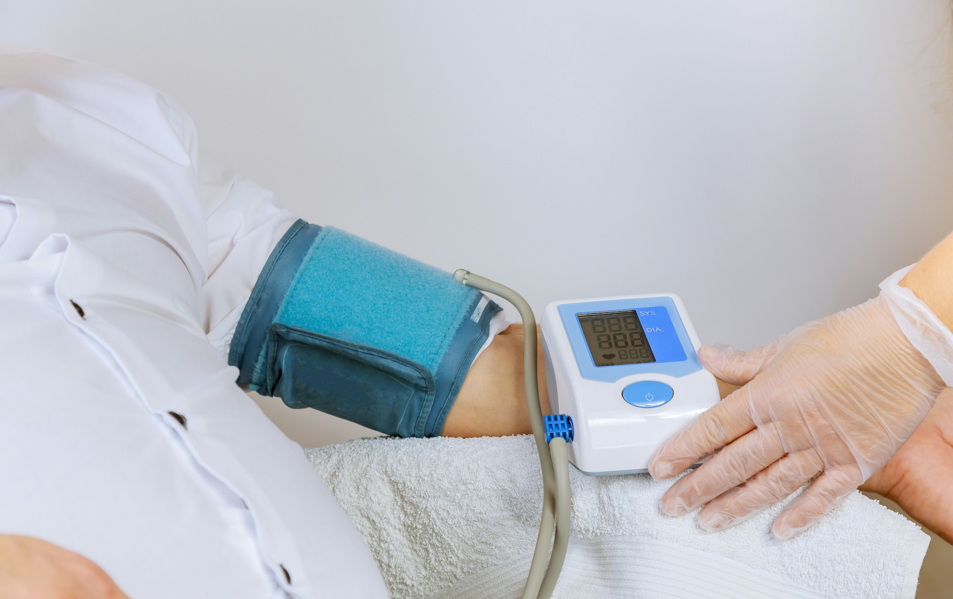 Doctor checking blood pressure with monitor, one of many habits that raise blood pressure worth tracking