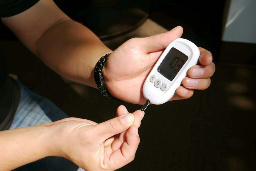 Person checking blood glucose with a fingerstick meter, monitoring blood sugar as goat's rue metformin has long helped manage type 2 diabetes