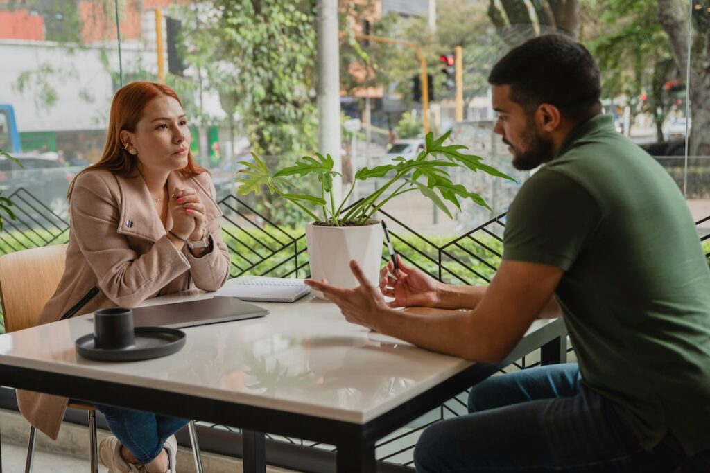 Man and woman deep in conversation at a café table, illustrating how speech patterns and brain health are connected