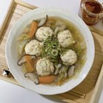 High protein soup with chicken meatballs, glass noodles, carrots and shiitake mushrooms in a white bowl