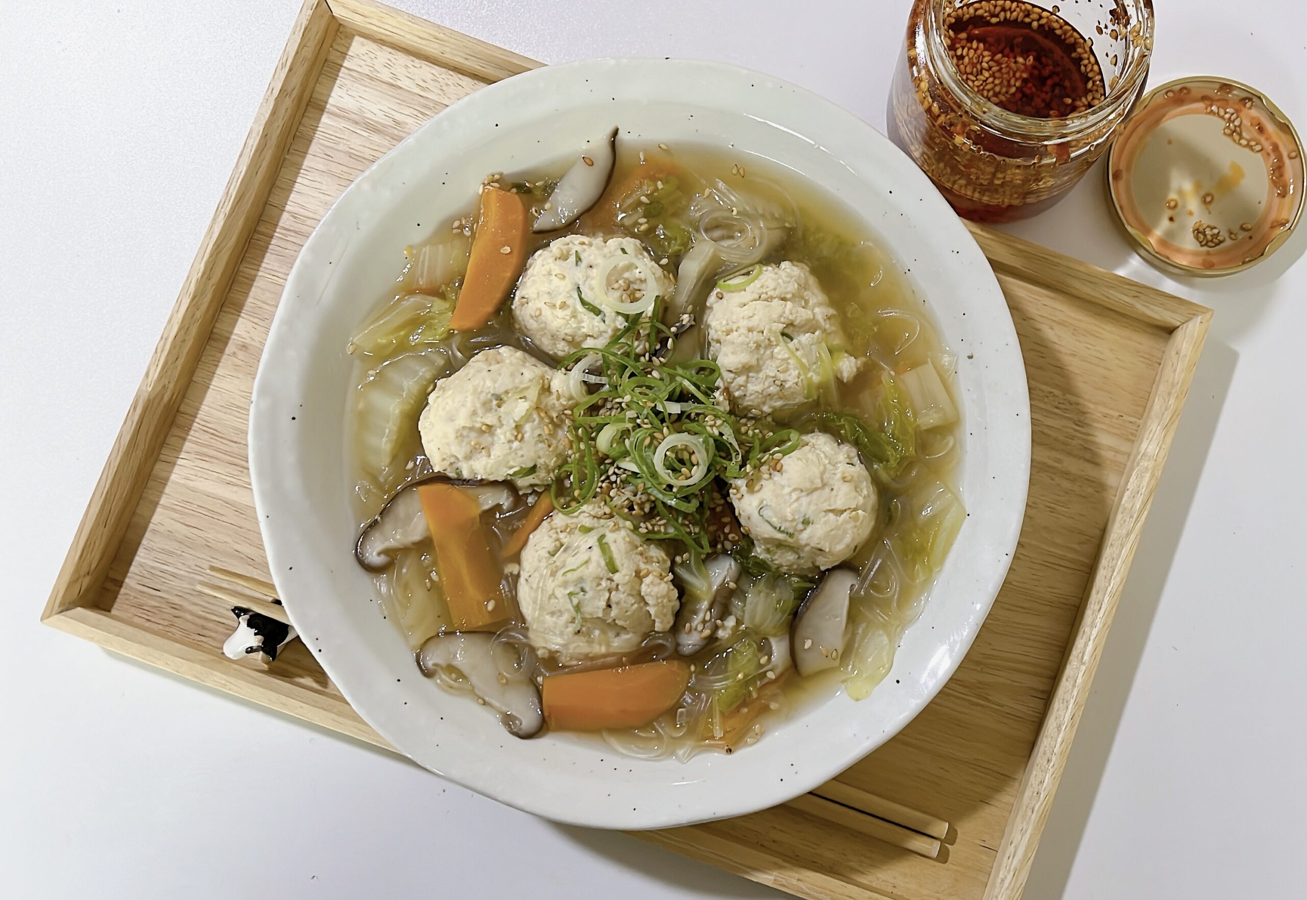 High protein soup with chicken meatballs, glass noodles, carrots and shiitake mushrooms in a white bowl