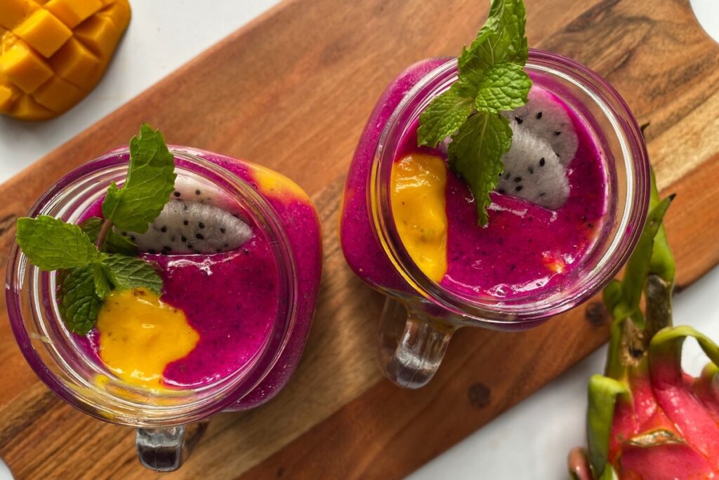 Layered dragon fruit mango smoothies garnished with mint, one of this week's easy meals under 30 minutes