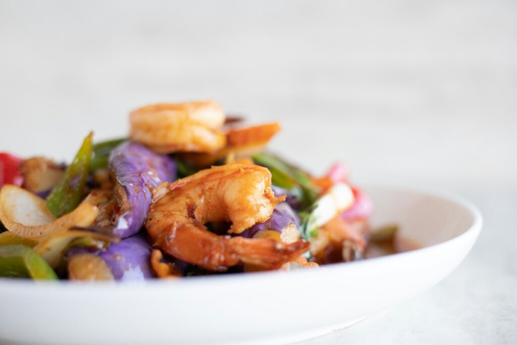 Plate of shrimp and vegetable stir-fry with peppers and cabbage, a low calorie meals idea for dinner