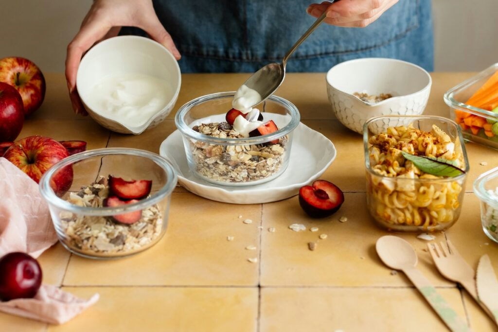 Plain yogurt spooned over muesli with fresh fruit, one of the best yogurt for gut health toppings