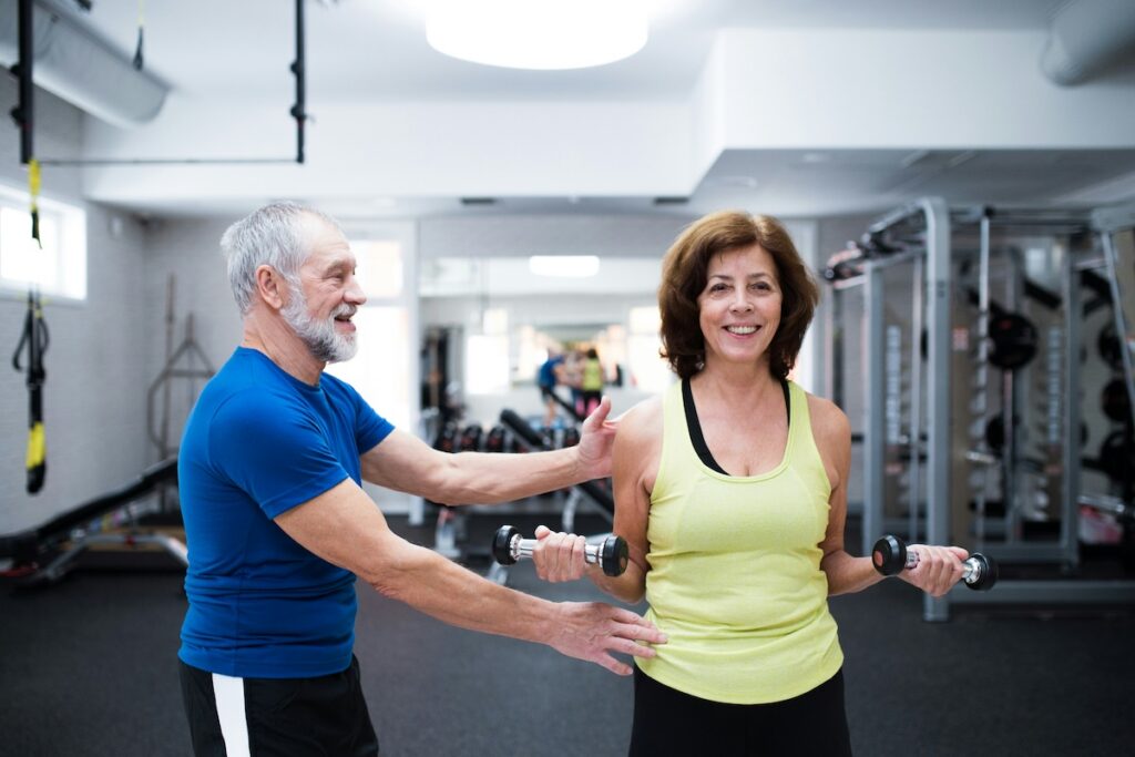 Older adults strength training with dumbbells, showing why protein powder older adults need exercise to preserve muscle