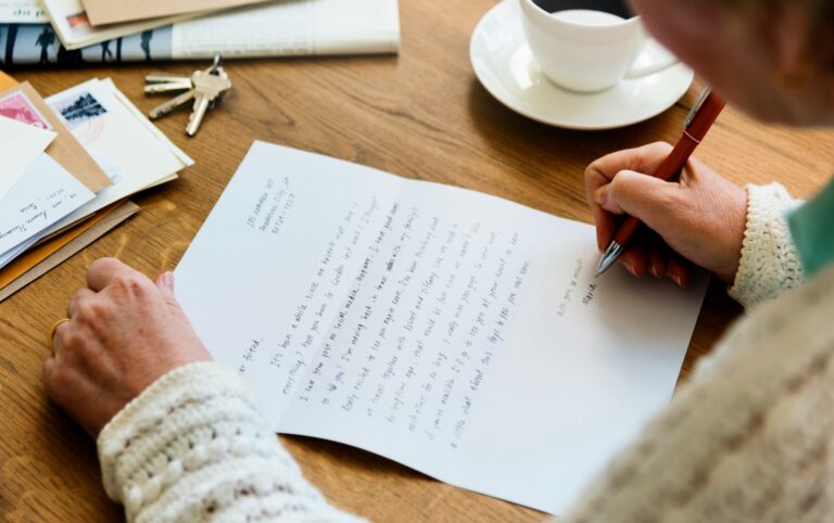 Older woman writing a handwritten letter by hand, a task tied to handwriting and cognitive decline research.