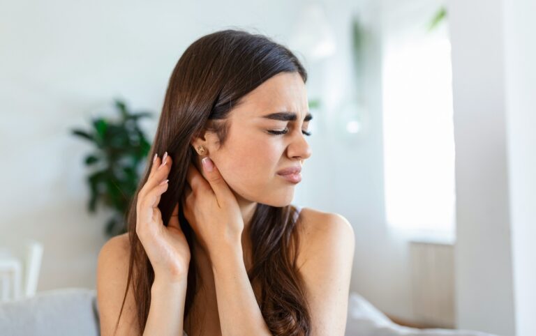 Woman experiencing ear discomfort, an early sign linked to hearing loss and dementia risk