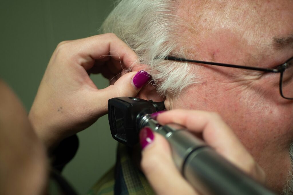 Audiologist performing an ear exam to screen for hearing loss and dementia risk early