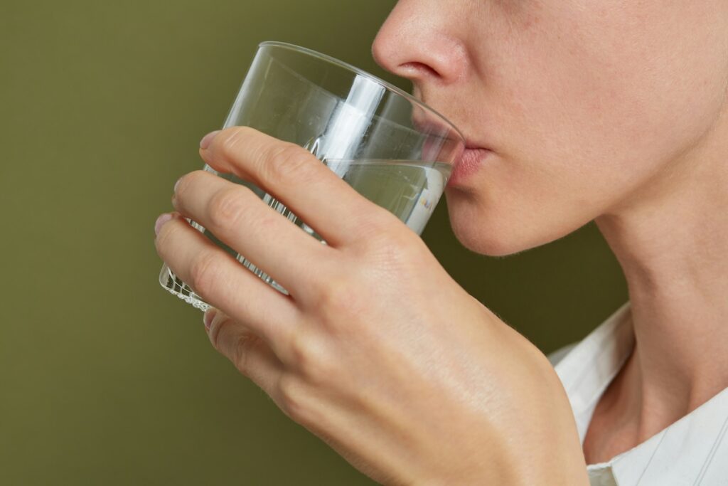 Woman drinking a homemade oral rehydration solution, one way to get electrolytes without supplements