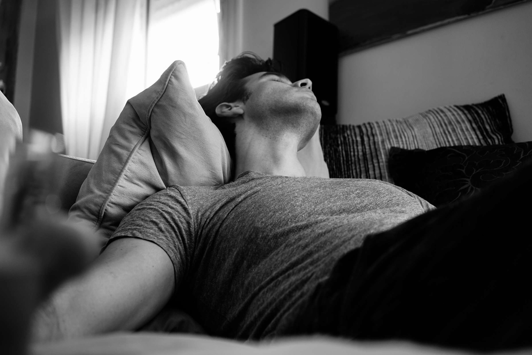 Man reclining with head propped up on a pillow — pillow height and eye pressure can affect glaucoma risk during sleep