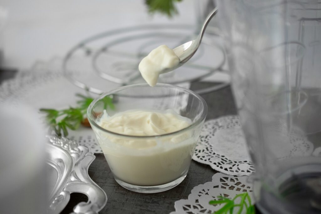 Spoonful of creamy yogurt, a fermented food for gut health, lifted from a glass bowl