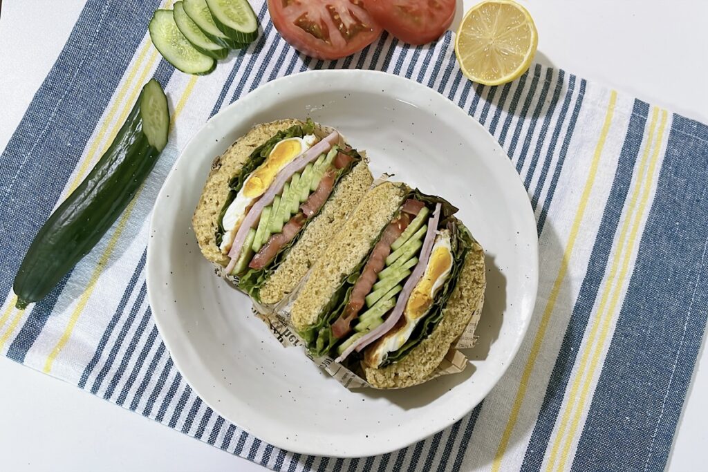 Gluten-free breakfast sandwich with ham, egg, cucumber, and tomato on oat bread, one of six simple healthy meals