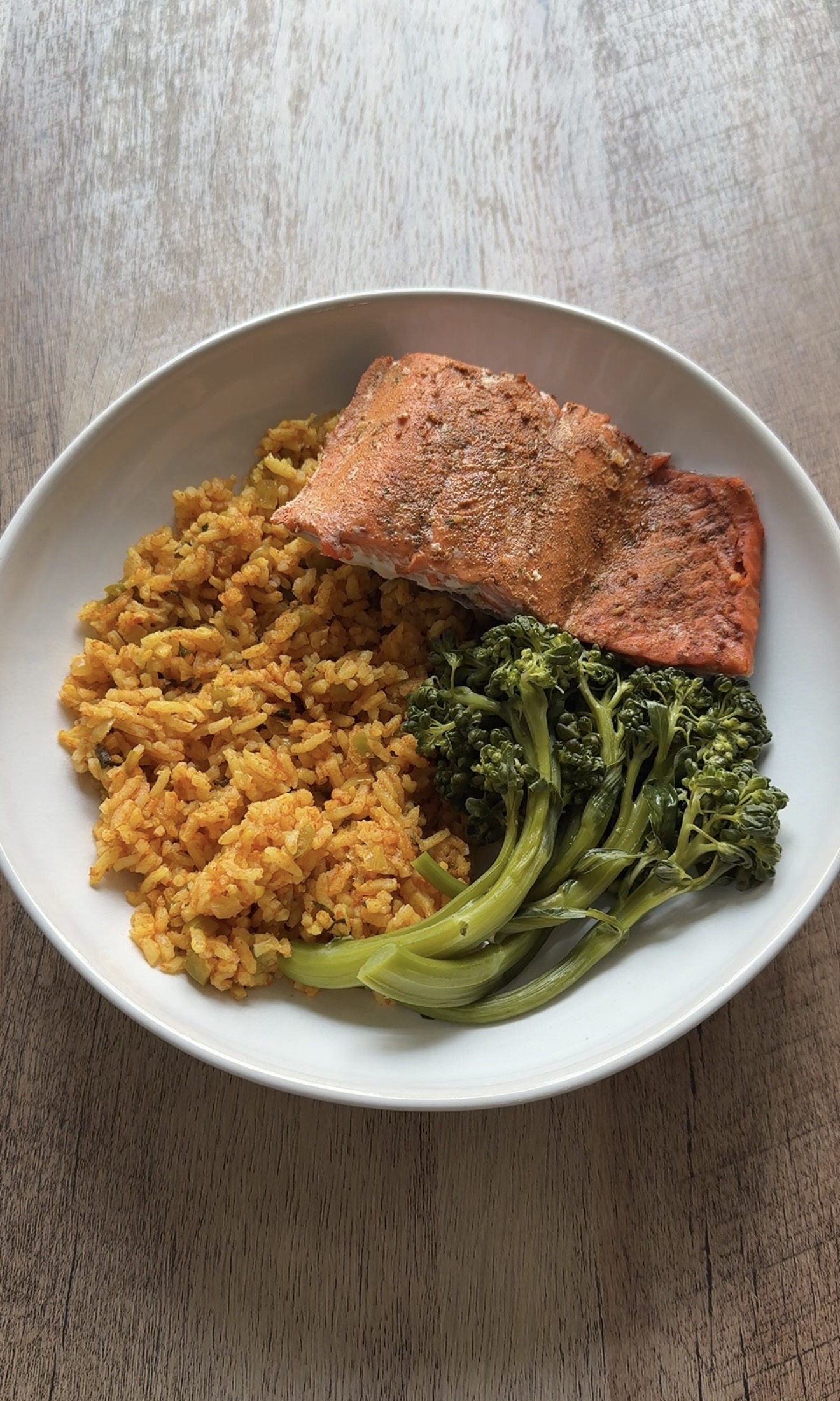 Salmon rice bowl base with baked taco-seasoned salmon, homemade Spanish rice, and steamed broccolini