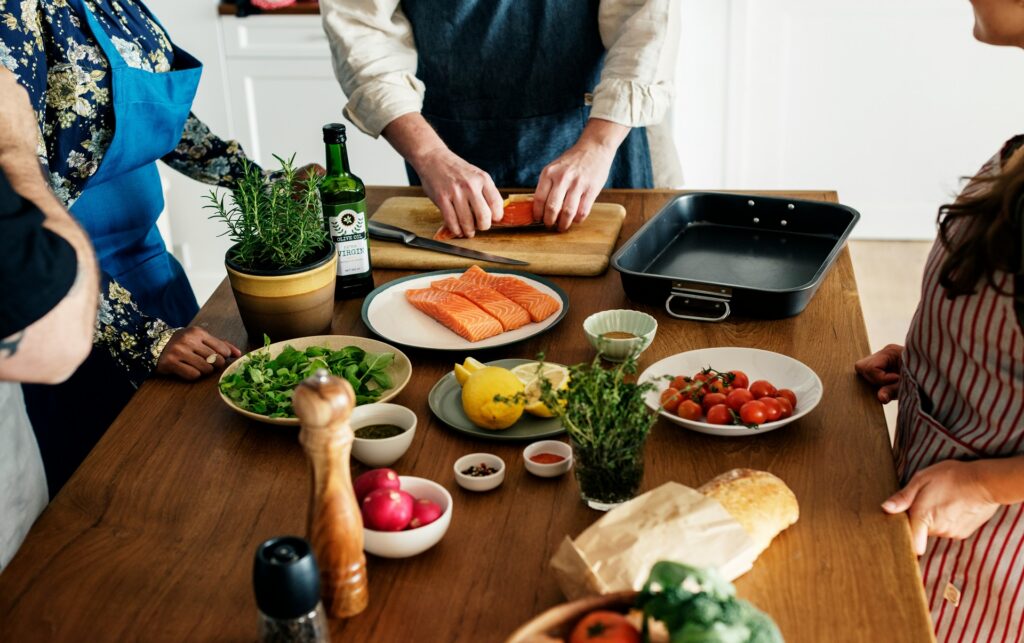 Salmon fillets, fresh greens, and vegetables on a kitchen table, the best food for blood pressure.