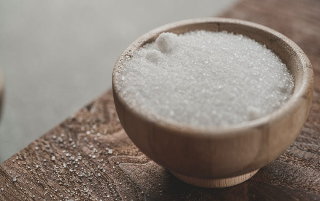 Wooden bowl of white crystals on a table, illustrating xylitol and heart attack risk
